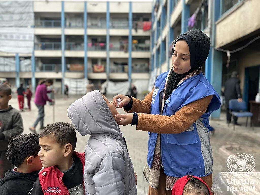 <div class='fn'> A displaced child receives a polio vaccination in UNRWA shelter in Beach camp , Gaza Strip</div>